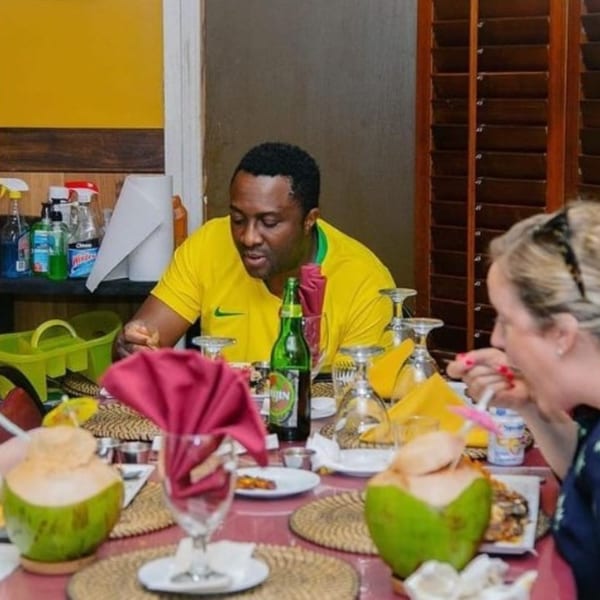Diners enjoying a meal at Drelyse African Restaurant, with fresh coconuts and drinks on the table.
